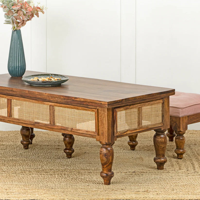 Wooden coffee table with wicker side panels in a living room setting.